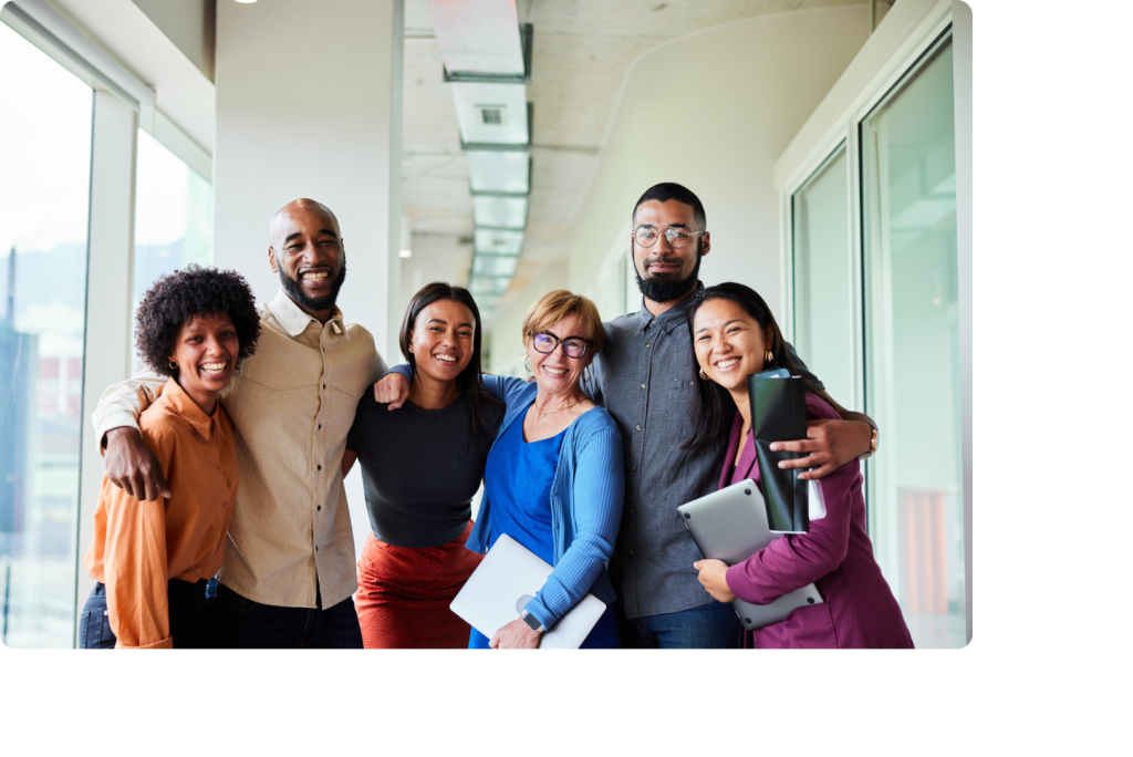 Groupe de collaborateurs souriants dans un couloir d'entreprise