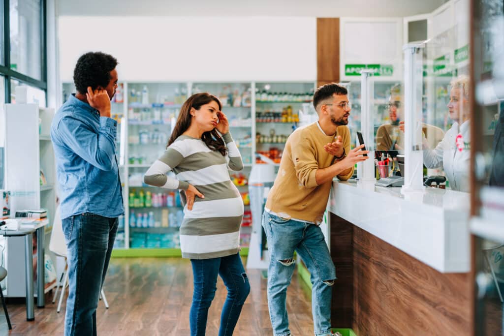 Trois patients dans une file d'attente en pharmacie