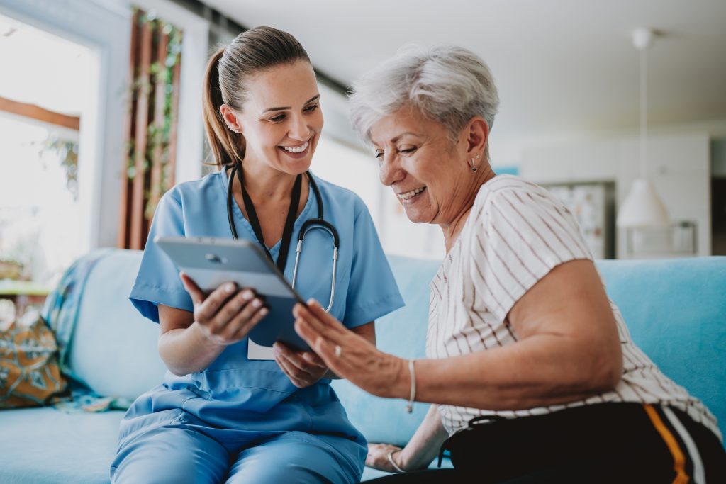 Infirmiere utilisant une tablette avec une patiente