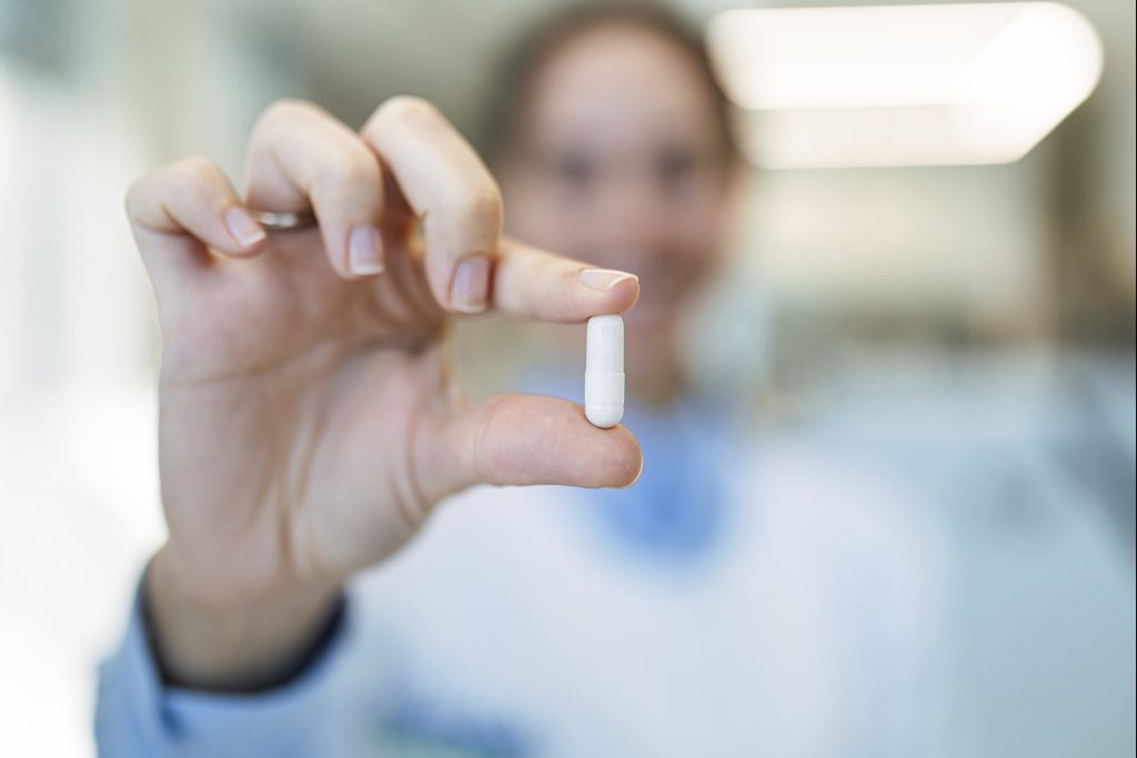 Pharmacienne qui montre une gélule