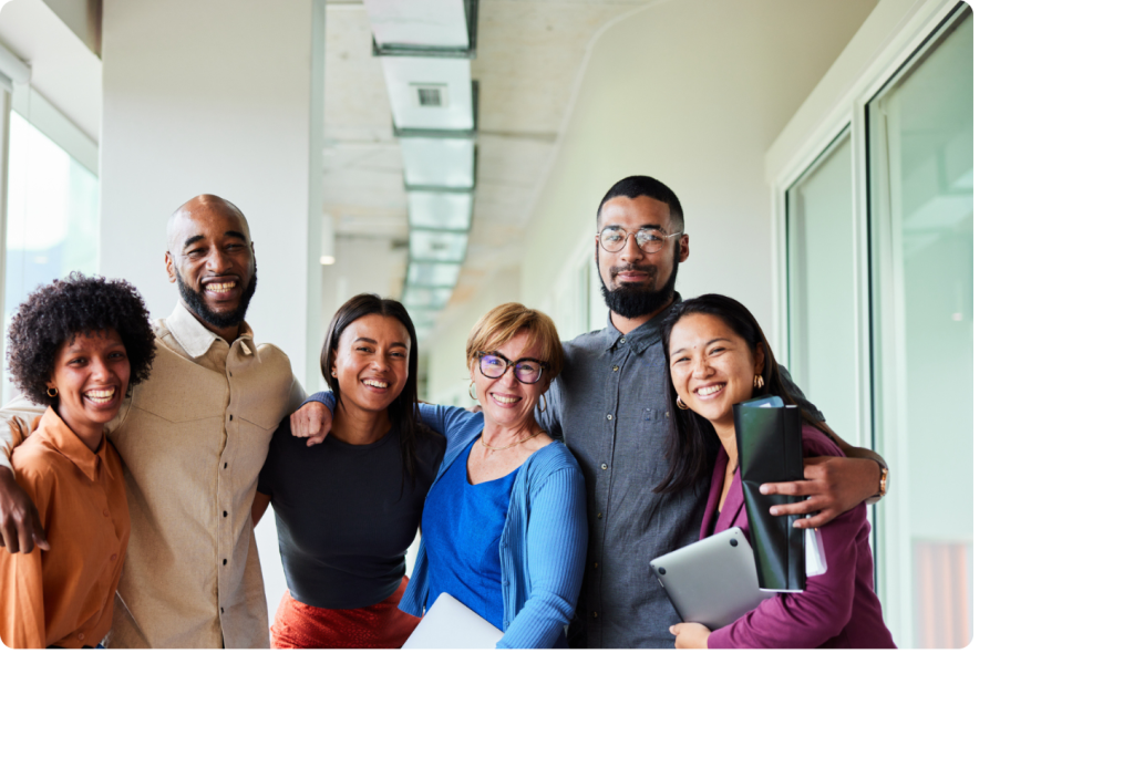 Equipe d'hommes et de femmes souriants dans un couloir d'entreprise