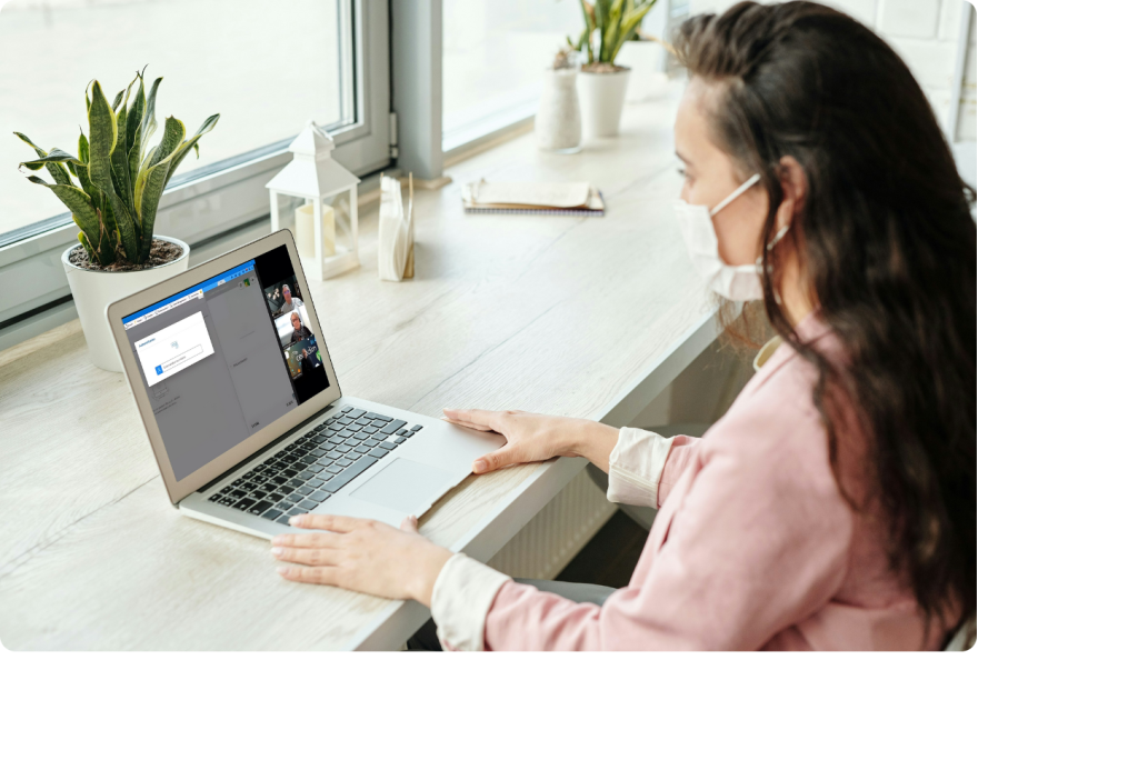 Femme en train de suivre un atelier de formation en ligne sur son ordinateur portable assise à un bureau