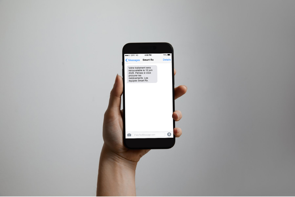 Main qui montre un smartphone avec un sms de rappel
