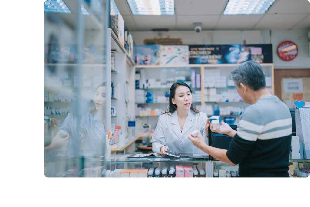 Pharmacienne discutant avec un patient et caméra de vidéosurveillance au comptoir