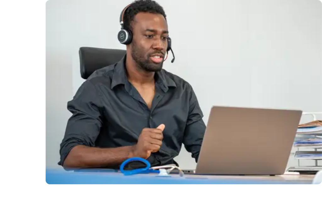 Homme en chemise avec casque sur la tete en train de discuter à distance via un pc portable