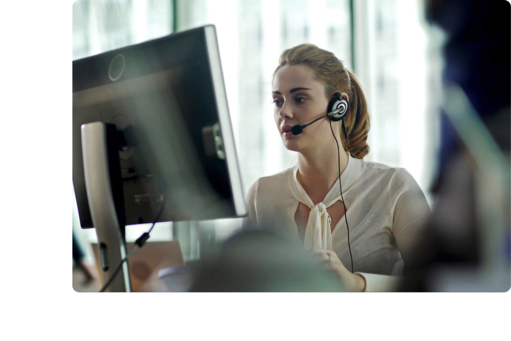 Femme avec un casque et un micro devant un écran d'ordinateur dans un bureau