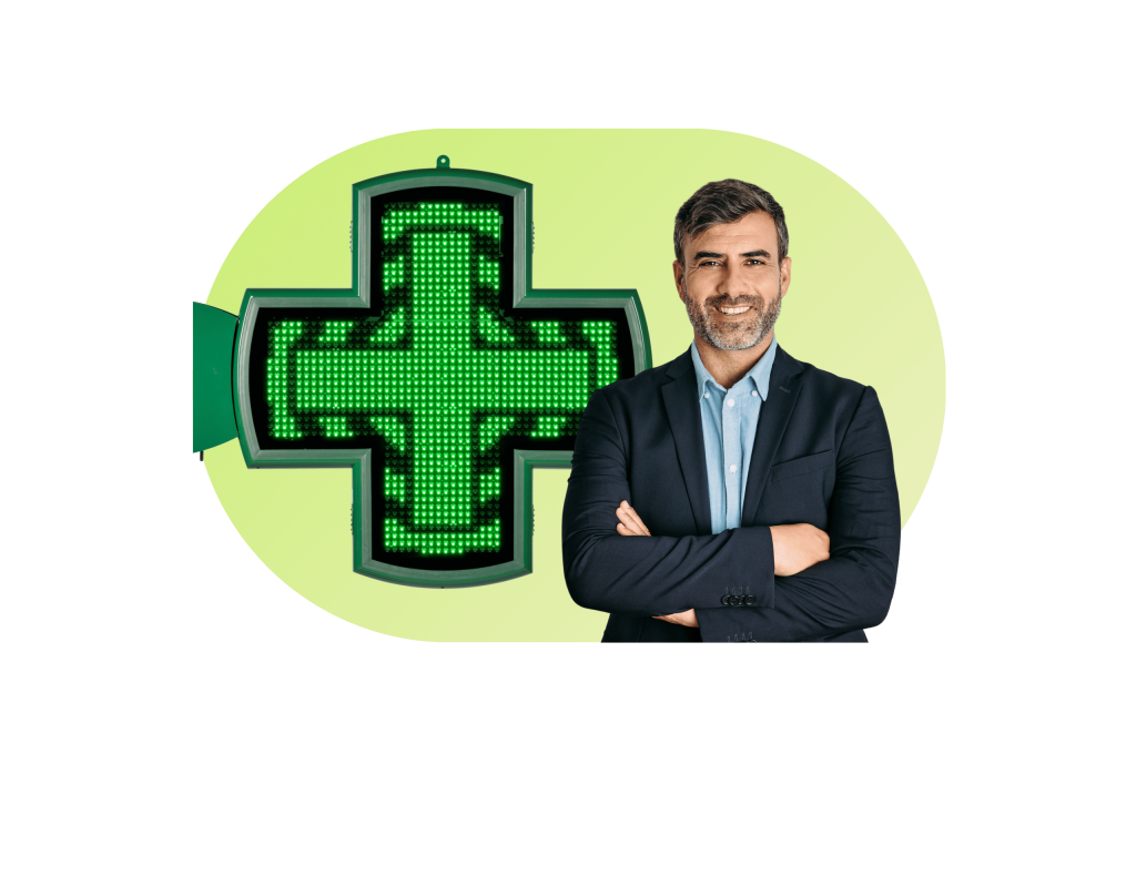 Homme en veste et chemise les bras croisés avec une croix de pharmacie derrière lui