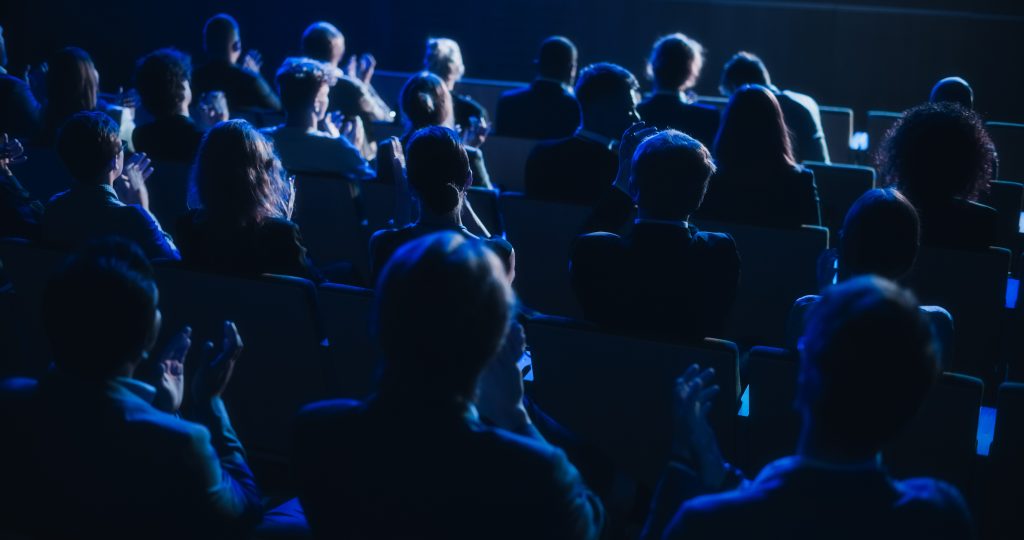 Personnes assises et dans la lueur d'un projecteur