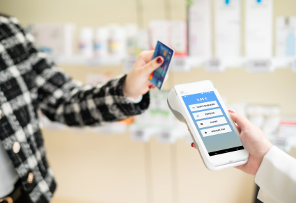 Cliente qui paie en carte bancaire en pharmacie dans le rayon grâce au terminal de vente mobile NEV Mobile