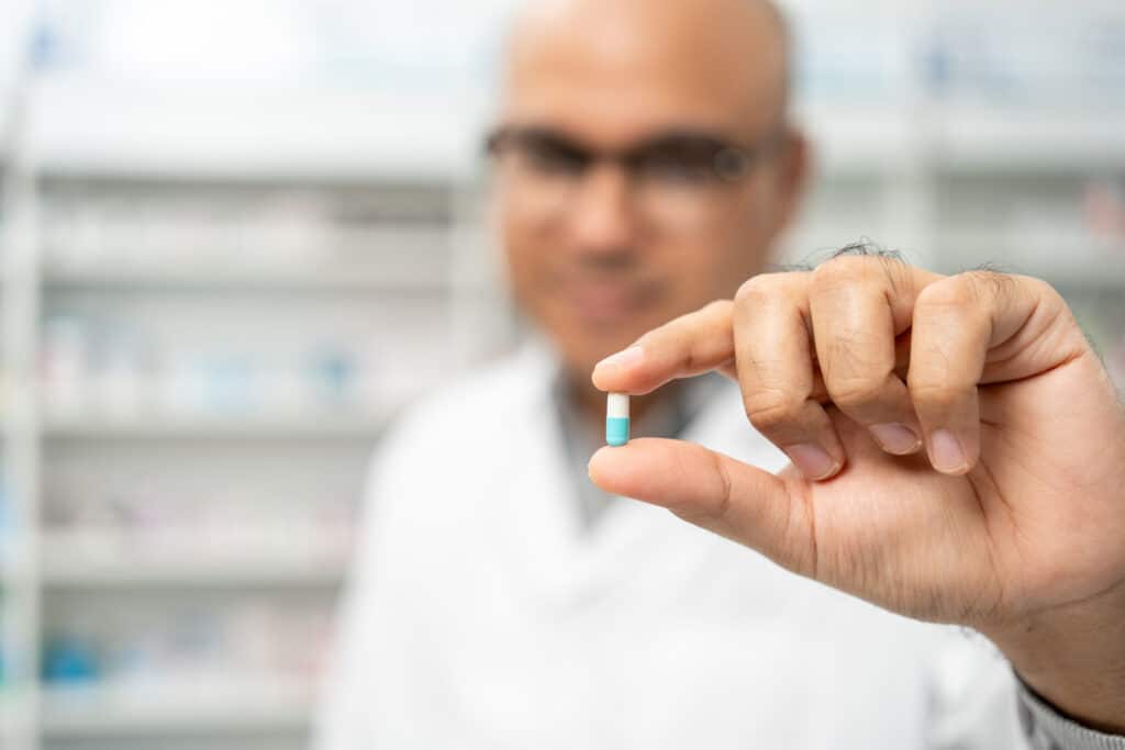 Pharmacien montrant une gélule de médicament