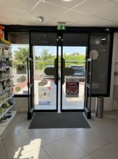 Photo d'un Smart Rx Portique à l'entrée d'une pharmacie à côté de la porte automatique.